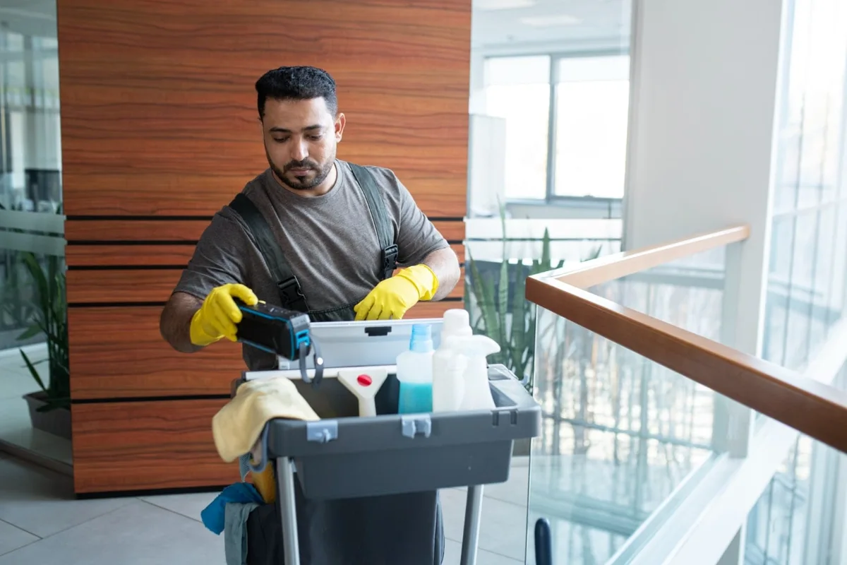 Cleaner carrying supplies through a commercial building